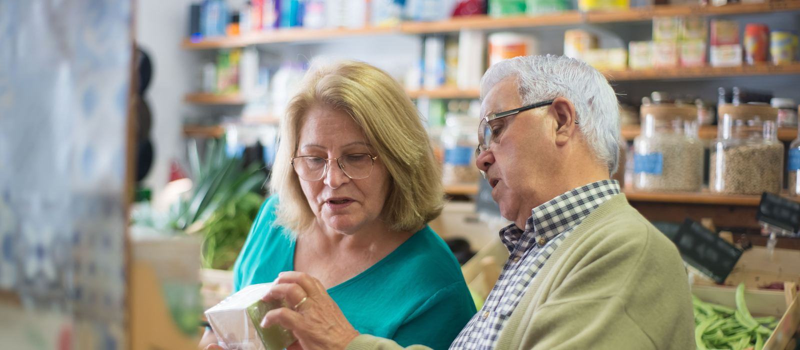 Two shoppers reading the label on a product in a small grocery shop